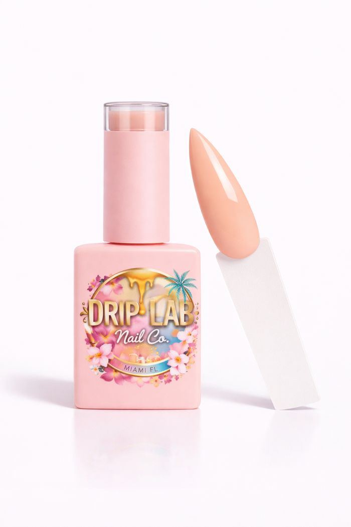 Pink nail gel polish bottle with a floral label next to a painted nail on a white background