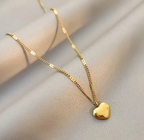 Close-up of geometric heart pendant on clavicle chain