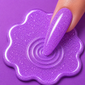 Purple glittery slime with a hand interacting with it on a purple background