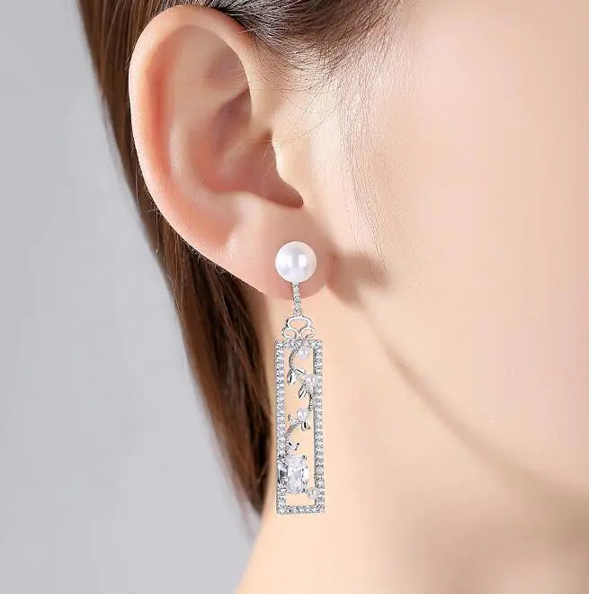Long pearl drop earrings with opal accents