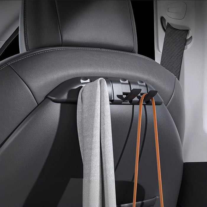 Tesla Model 3/Y seat-back organizer with open hooks holding a gray scarf and brown bag straps.