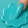 Turquoise glittery slime with a hand interacting with it on a teal background